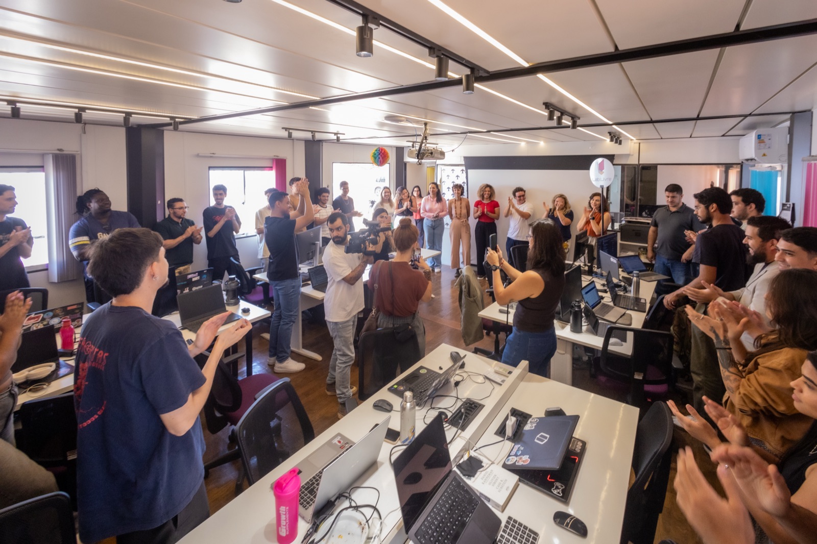 Equipe do laboratório aplaudindo na nova sede do Lab Livre em 2025